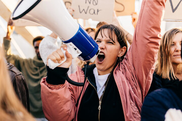 Diverse group of activists people holding posters and banners antiwar protesting against war and violence in the world.