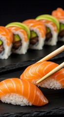  Fresh Salmon Nigiri and Maki Sushi Rolls with Chopsticks on a Dark Stone Plate