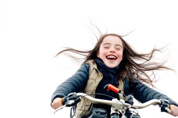 Fototapeta premium Portrait of a cheerful child with Down syndrome riding a bicycle with her hair blowing in the wind, expressing joy and freedom