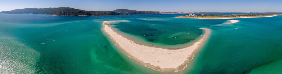Aerial drone panoramic view of beautiful sandy beaches stretching along the coastline of Troia, Portugal, as turquoise waters glisten under the bright sun