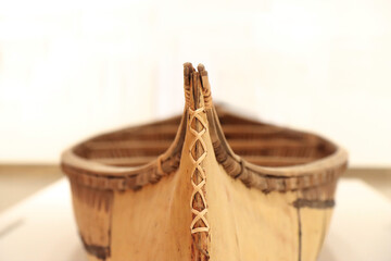Prow of an old birchbark canoe featuring spruce root stitching, indoors, nobody