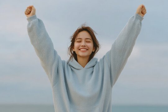 Joyful expression of happiness with open arms against serene bea