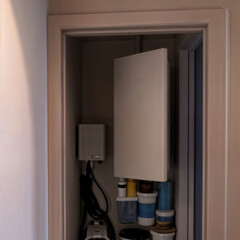 Home battery storage system. A wall-mounted energy storage unit, or powerwall, installed in a home closet for residential backup power.