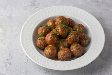 Köttbullar - Traditional Swedish meatballs with cream sauce, mashed potatoes, pickled cucumber, and lingonberry jam