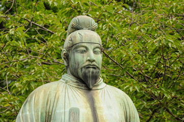 Fototapeta premium Japanese statue in lush greenery symbolizing heritage and tranquility