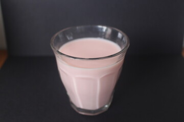 strawberry milk inside glass cup with black background