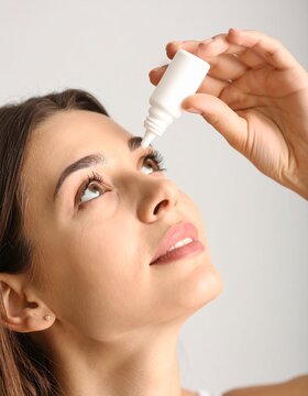 Una mujer administrando gotas para los ojos.