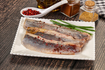Salted marinated herring fillet with spices