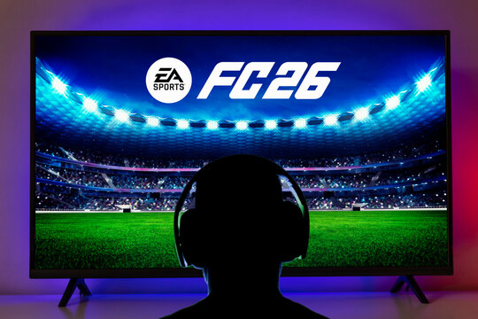Man with headphone playing new EA FC 26 on TV screen, 01 aug, 25, Sao Paulo, Brazil.