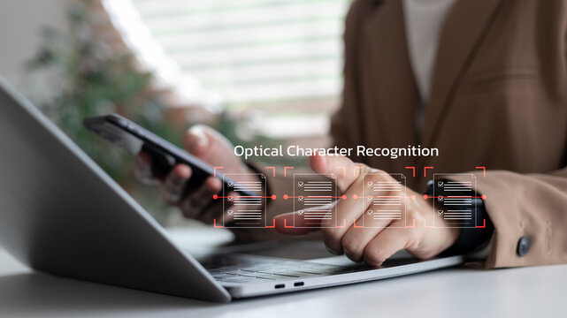 Close-up of a businesswoman using a smartphone and laptop with an OCR interface scanning documents. Concept of optical character recognition, AI document automation, and smart data extraction. - Powered by Adobe