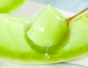 Fresh southway jade mushroom melon with juicy scoop on gold spoon