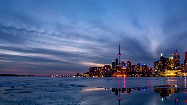 Toronto skyline at sunset with reflection in the water in winter