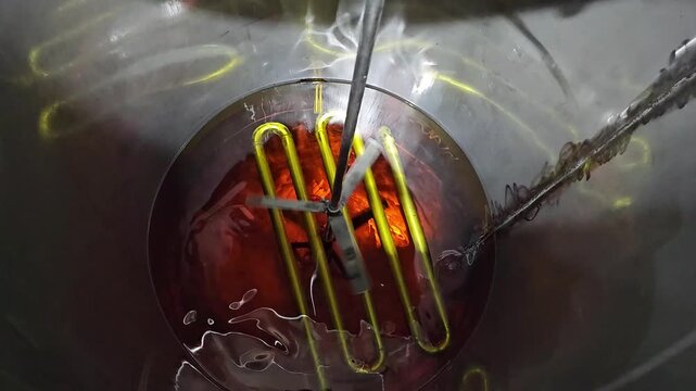 Industrial Mixer Stirring Liquid in a Stainless Steel Tank. This is footage of a rotating mixer or agitator inside a large, stainless steel industrial tank for mixing Vitamin A and edible oil.