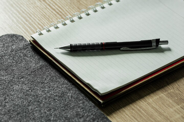 Open black spiral notebook and pen on a blank page for business notes and education