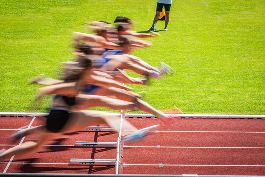 women crossing the hurdles during a race