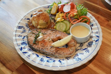 Grilled Salmon steak breast with fresh vegetables on a white plate