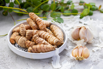 Fresh and Ground Turmeric Root on Rustic Background