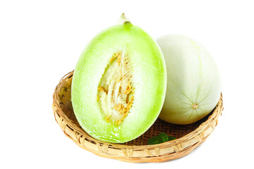 Fresh Shandong white bottom jade mushroom melon cut in half on a woven basket showcasing its vibrant green flesh