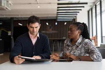 Team of diverse businessman and businesswoman discuss and working, brainstorming together with digital tablet on desk office in the office workspace