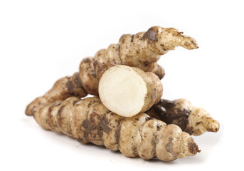 Fresh ground loop pagoda cabbage roots piled for culinary use in a white background setting showcasing their unique shape and texture