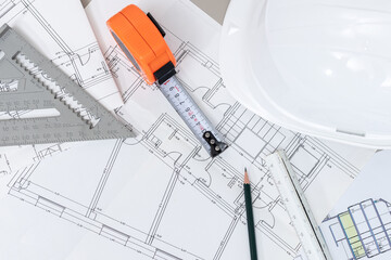 Top View of a builder workbench with blueprints, tape measure, and other construction tools
