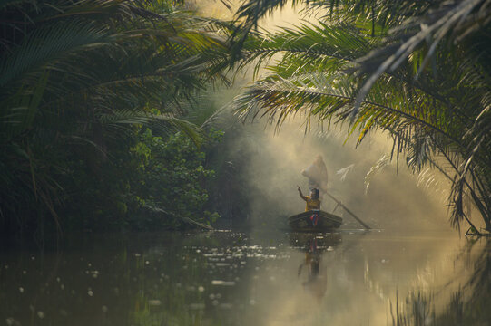 Man and woman sailing in a traditional yo vessel, Klong Pak Pra, Phatthalung, Thailand