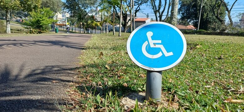 Kleines blaues Rundschild mit Rollstuhlsymbol &ndash; Barrierefreier Zugang in brasilianischem Park