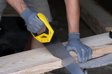 Carpenter working with a saw in a carpentry workshop.