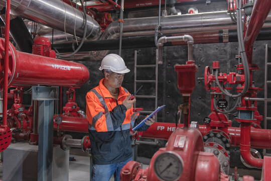 engineer checking and inspection pressure ,pipeline in fire pump room. High Pressure Water Pump Diesel engine.	
