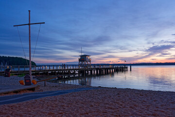 Seaside pier and lifeguard tower after sunset in Gluecksburg in Northern germany near Flensburg