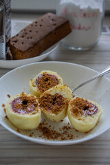 Sweet plum dumplings on white plate, with white sugar icing and grated gingerbread, delicious czech cuisine