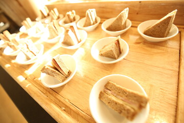 Elegant indoor banquet setup with warm lighting, neatly arranged glassware, folded napkins, and floral accents — perfect for a formal event or celebration.