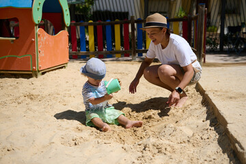 Mother and Child Enjoying Playtime in a Sunny Park Sandbox Playground