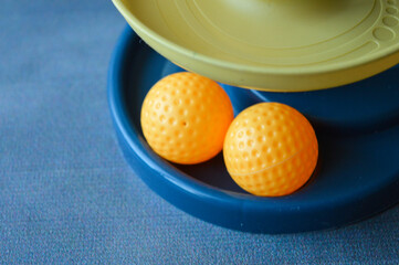 assembled colorful plastic ball ramp toy with bear face and spiral tracks. yellow balls rest on the base, ready to roll down. educational and playful design for young children.