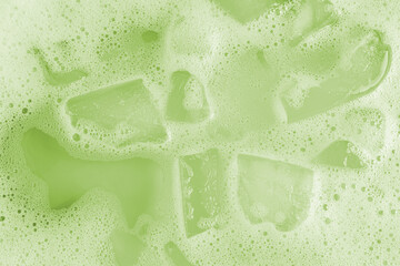 Iced matcha background with green frothy texture