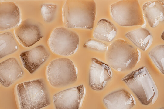 Iced coffee cubes floating in cold brew close-up