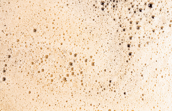 Macro view of frothy coffee foam texture in detail
