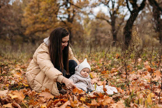 Mother and child enjoying fall in a leafy park