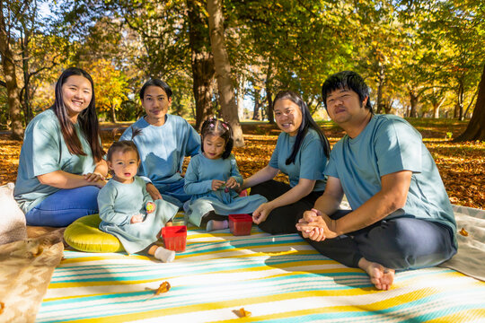 Asian family enjoying an autumn picnic in the park