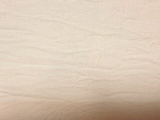 light beige cotton fabric texture with natural wrinkles ideal for neutral background or textile design mockup

