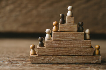 A wooden pyramid with small wooden figures standing on each level of the structure indoors