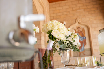 Elegant floral arrangement enhances the charm of a serene setting at a gathering amidst rustic architecture and soft natural light