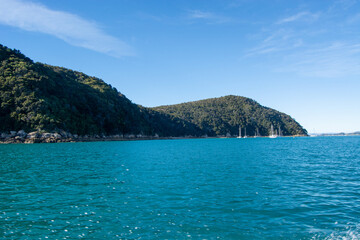 Serene Coastal View with Turquoise Sea and Green Hills