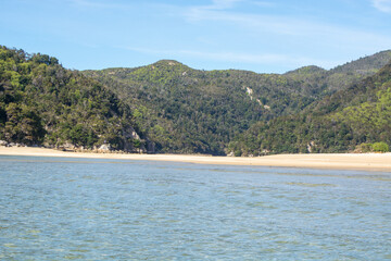 Serene Beach Surrounded by Lush Green Hills