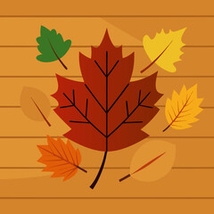 Naklejka premium Colorful autumn leaves scattered on a wooden background