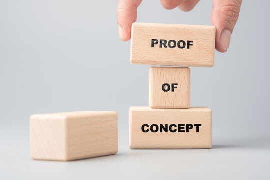 Hand placing wooden blocks with the words proof of concept, symbolizing idea validation, business planning, and innovation testing
