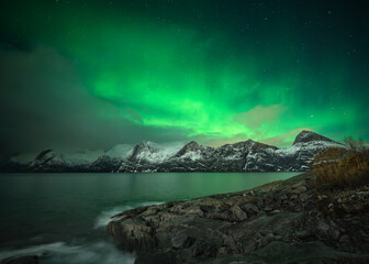 Northern lights over the snowy mountains of Senja, Norway