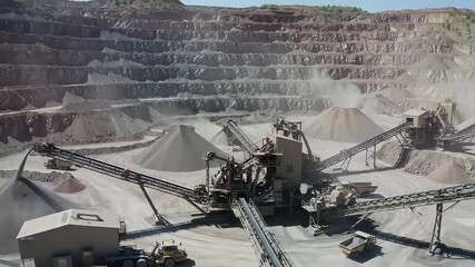 A busy mining site showcases machinery transporting minerals and managing excavation activities in a quarry landscape.