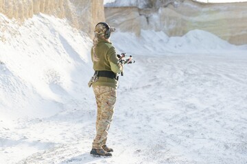 Female soldier holding a rifle during military training in winter