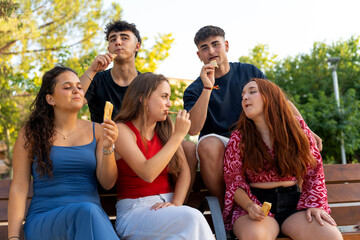 Generation z friends enjoying snacks in a park